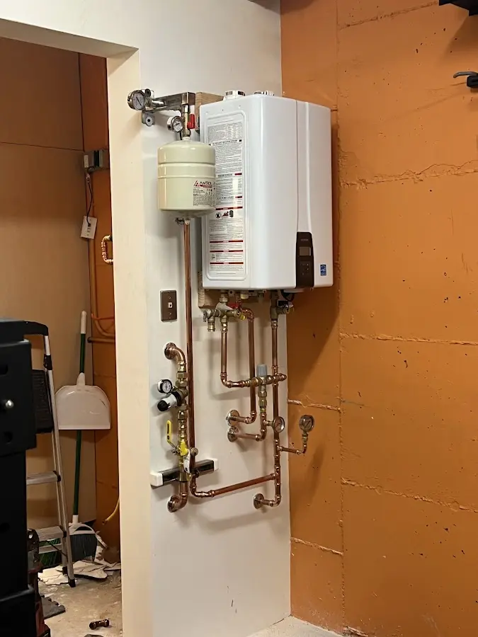 Plumbing technician inspecting water heater connections in Bonsall